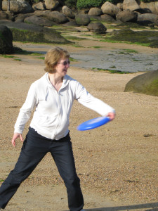 Fiona playing frisbee on the beach at Ploumanach