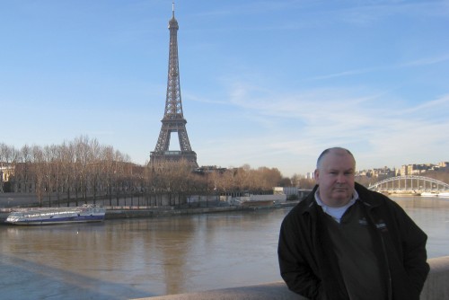 John beside the river Seine near the Eiffel Tower in Paris