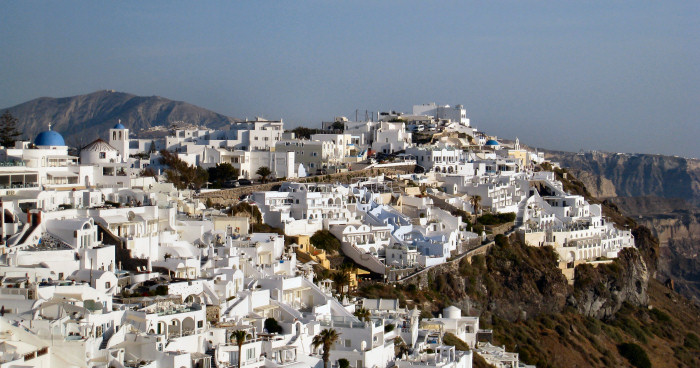whitewashed buildings and blue domed churches in Firostefani, Santorini.
