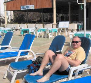 John relaxes by the hotel pool on holiday in Tunisia