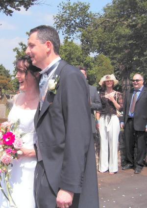 Jan and Matthew outside the abbey with wedding guests